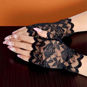 Puede incluir: Guantes sin dedos de encaje negro con un dise&ntilde;o floral de rosas. Los guantes tienen un borde festoneado y est&aacute;n hechos de un material delicado y transparente. Un accesorio elegante para ocasiones especiales.