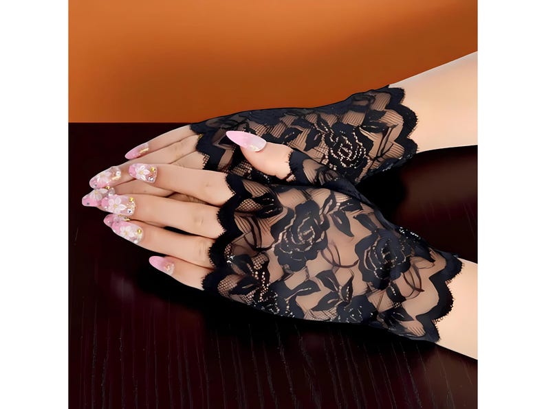 Puede incluir: Guantes sin dedos de encaje negro con un dise&ntilde;o floral de rosas. Los guantes tienen un borde festoneado y est&aacute;n hechos de un material delicado y transparente. Un accesorio elegante para ocasiones especiales.