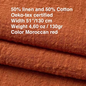 Op de afbeelding: Marokkaans rode stof gemaakt van 50% linnen en 50% katoen. Het materiaal is Oeko-tex gecertificeerd, met een breedte van 130 cm en een gewicht van 130 gram. Het textiel heeft een zichtbaar, getextureerd weefpatroon over het gevouwen oppervlak.