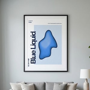 May include: A framed poster with the words "Blue Liquid" in bold, vertical text. The poster features a blue, abstract shape against a light blue background. The poster is hanging above a gray sofa with decorative pillows.