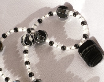 Collar con cuentas en blanco y negro con acentos de hematita semipreciosas y colgante de obsidiana