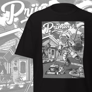 Könnte beinhalten: Schwarzes T-Shirt mit einem Graustufen-Grafik eines Astronauten, der einen Rasen mäht. Das Bild enthält das Wort "Primus" in einer stilisierten Schriftart. Der Astronaut trägt einen Raumanzug und schiebt einen Rasenmäher.