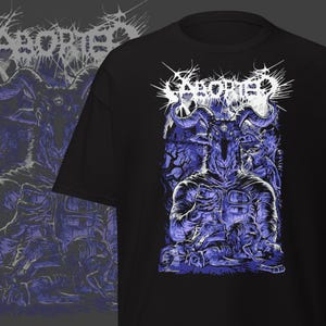 May include: Black t-shirt featuring a detailed illustration of a horned figure with the word "ABORTED" in white above. The design is predominantly purple and white, with a gothic or metal theme.