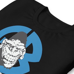 May include: Black t-shirt with a gorilla graphic in blue and white. The gorilla has a stern expression and is set against a blue letter "R" shape. The shirt is made of a soft material.