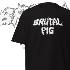 May include: Black t-shirt with the white text "BRUTAL PIG" in a distressed, jagged font. The shirt has a crew neck and short sleeves. The design is centered on the front of the shirt.