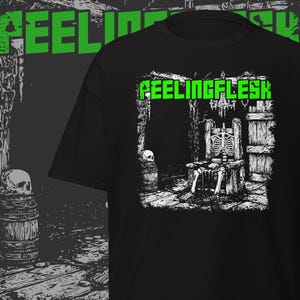 May include: Black t-shirt with a white and green graphic design. The design features the text "FEELINGFLESH" in green, along with a skeleton seated in a wooden chair. A skull and barrel are also visible.