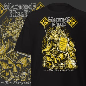Puede incluir: Camiseta negra con un diseño gráfico amarillo y blanco de un rey esqueleto sosteniendo un letrero que dice "The Mirror which Flatters not". La camiseta también tiene el nombre de la banda "Machine Head" y "The Blackening".