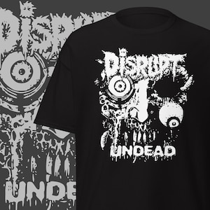 Puede incluir: Camiseta negra con un diseño gráfico blanco de una calavera con las palabras "DISRUPT" y "UNDEAD". El diseño tiene una estética grunge y desgastada. La camiseta es de cuello redondo clásico.