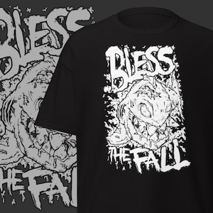 Puede incluir: Camiseta negra con un diseño gráfico blanco. El diseño presenta la palabra "BLESS" sobre una ilustración detallada de una criatura, con las palabras "THE FALL" debajo. El diseño es de estilo audaz e ilustrativo.