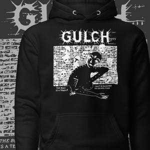 May include: Black hoodie featuring the word "GULCH" in a distressed font above a graphic. The graphic depicts a figure with a brick wall background and the phrases "THE BODY IS A TEMPLE" and "THAT IS DAMNED TO DEMOLITION".
