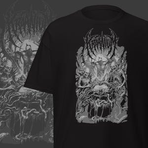 May include: Black t-shirt featuring a detailed grayscale graphic of a demonic scene with skeletal figures and intricate, gothic-style lettering at the top. The design has a dark, heavy metal aesthetic.