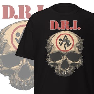 May include: Black t-shirt featuring a distressed skull graphic with the text "D.R.I." in red letters. The skull has a circular design with a running figure inside. The design is centered on the shirt.