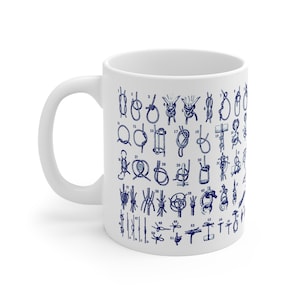 Puede incluir: Taza de cerámica blanca con un diagrama azul marino de varios nudos marinos. La taza tiene un asa estándar y un acabado brillante, ideal para los amantes de la náutica.