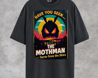 May include: Dark gray t-shirt featuring a vintage-style graphic of the Mothman. The design includes the text "Have You Seen... The Mothman - Terror from the Skies" with a colorful illustration of the cryptid.