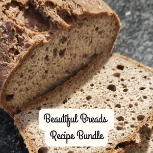 以下が含まれることがあります： 部分的にスライスされた、焼きたてのパン。テクスチャとゴマが確認できます。パンは薄茶色で、白い背景に「Beautiful Breads Recipe Bundle」の文字があります。