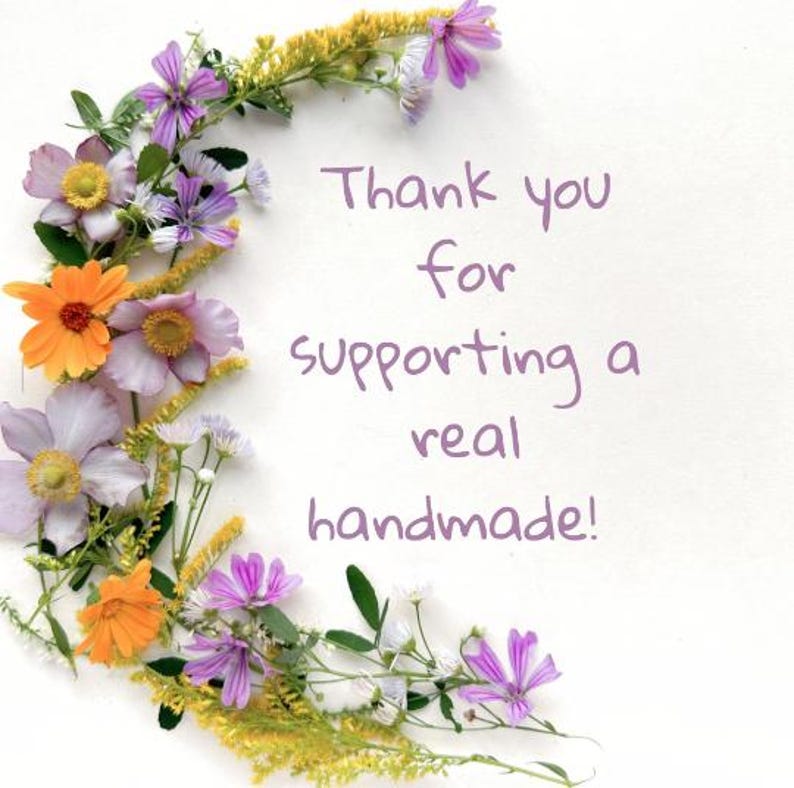May include: A white background with a floral arrangement of orange, purple, and yellow flowers. The text reads, "Thank you for supporting a real handmade!"