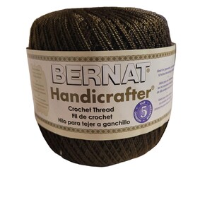 May include: A ball of brown Bernat Handicrafter crochet thread with a label that says "Crochet Thread, Fil de crochet, Hilo para tejer a ganchillo" and a size 5 label.