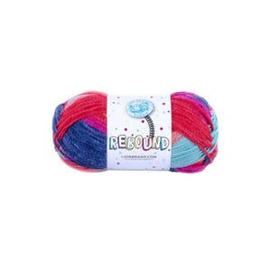 May include: A colorful skein of Lion Brand Rebound yarn. The yarn is a mix of red, blue, pink, and turquoise. The label reads "REBOUND" and "LIONBRAND.com". The yarn is suitable for knitting and crochet projects.