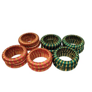 May include: A collection of six decorative ring-shaped objects. Three are red with gold stripes, and three are green with gold stripes. The rings are arranged in a group, with some stacked on top of each other.