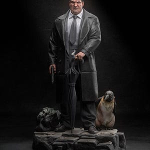 May include: A detailed statue of a man in a long black coat, holding an umbrella and a gun. A penguin stands beside him on a stone base. The figure is dressed in a suit and tie.