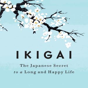 Può includere: Copertina del libro "Ikigai: Il segreto giapponese per una vita lunga e felice". La copertina presenta uno sfondo azzurro chiaro con un ramo di fiori di ciliegio bianchi. Il titolo è in grandi lettere nere, con i nomi degli autori in basso.