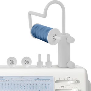 May include: A white sewing machine with a blue spool of thread mounted on a white thread stand. The machine has a digital display and several dials and buttons. The image shows the machine's features.