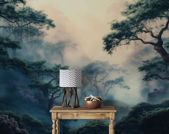 May include: A decorative lamp with a gray and white chevron pattern lampshade sits on a wooden table. The table also holds a small bowl with decorative items. The background is a mural of a misty forest scene.