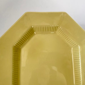 May include: A yellow octagonal serving platter with a raised, textured rim.