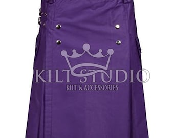 May include: A solid purple kilt with silver-colored metal accents. The kilt features pleats, pockets, and decorative buttons. The text "KILT STUDIO KILT & ACCESSORIES" is printed on the front. This garment is suitable for formal or casual wear.