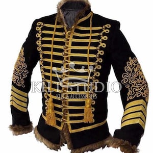 May include: Black military-style jacket with gold embroidery and trim. The jacket features multiple rows of gold braid, decorative gold buttons, and gold tassels. The collar and cuffs are trimmed with faux fur. The text "KILT STUDIO KILT & ACCESSORIES" is visible.