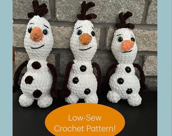 Könnte beinhalten: Drei weiße gehäkelte Schneemannfiguren mit orangefarbenen karottenförmigen Nasen, dunkelbraunen zweigartigen Armen und Haaren sowie schwarzen Knopfakzenten. Eine orangefarbene ovale Grafik unten enthält den weißen Text Low-Sew Crochet Pattern!
