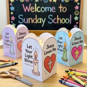 May include: Three paper lanterns featuring hand-colored illustrations of a candle and a heart with a cross. Each lantern displays the text Let Your Light Shine, Matthew 5:16, and Jesus Loves Me. The lanterns are arranged with crayons and scissors.