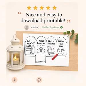 May include: A white lantern with a lit candle sits beside a printable paper craft featuring four panels with religious text and illustrations including a candle, heart with cross, bible, and footprints, with a red crayon resting on the paper.
