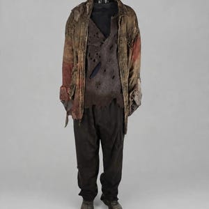 May include: A distressed ensemble featuring a brown, weathered jacket with frayed edges and patches, layered over a dark, tattered, hole-ridden vest and a solid black shirt. The outfit includes plain black trousers and dark, worn-in utility boots.