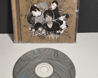 Op de afbeelding: Een cd-hoesje en -schijf voor het album "Every Second Counts" van Plain White T's. De cd-hoes heeft een bruine cover met de gezichten van de bandleden en de albumtitel in blauw. De cd zelf is zilverkleurig.