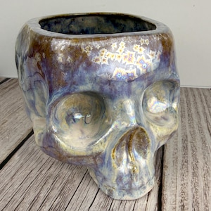 May include: A set of three ceramic mugs with a speckled, matte finish. The mugs are in shades of cream, light gray, and dark gray. Each mug has a simple, minimalist design, perfect for coffee or tea.