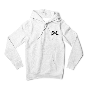 May include: A pale grey hooded sweatshirt with a drawstring hood and a front pocket. The sweatshirt has the letters "S&L" in black on the upper chest. The garment is made of a soft, comfortable material.