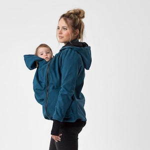 以下が含まれることがあります： 赤ちゃんを運ぶように設計された、フードとジッパーが付いたティール色のベビーウェアリングジャケット。 ジャケットは人が着用し、赤ちゃんは中にいます。 ジャケットは柔らかい素材で作られています。