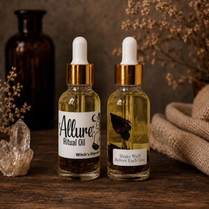 Puede incluir: Dos frascos cuentagotas de vidrio transparente con l&iacute;quido amarillo y elementos bot&aacute;nicos. La etiqueta izquierda dice Allure Ritual Oil Witch's Haven. La derecha dice Shake Well Before Each Use. Ambos frascos tienen cuellos dorados y tapas blancas.