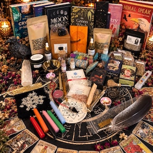 Puede incluir: Una colección de objetos ocultistas que incluye cartas del tarot, libros titulados Animal Speak y The Moon Phases, varias hierbas en bolsas, velas, una figura de cuervo negro, un péndulo, cristales e incienso sobre una alfombra.