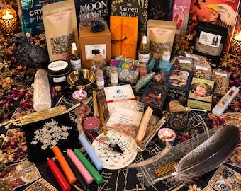 Könnte beinhalten: Eine Sammlung okkulter Gegenstände, darunter Tarotkarten, Bücher mit den Titeln Animal Speak und The Moon Phases, verschiedene Kräuter in Beuteln, Kerzen, eine schwarze Rabenfigur, ein Pendel, Kristalle und Räucherstäbchen auf einer Matte.