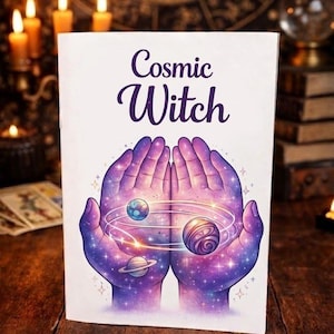 May include: A white book cover with the words "Cosmic Witch" in purple script. The cover features a cosmic illustration of hands holding planets and stars in shades of purple and blue.