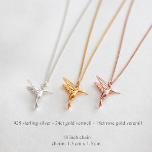 K&ouml;nnte beinhalten: Drei Halsketten mit Kolibri-Anh&auml;ngern in Silber, Gold und Ros&eacute;gold. Jede Halskette hat eine Kette von ca. 45.7 cm und einen Anh&auml;nger von 1,5 cm x 1,5 cm. Der Text zeigt die Materialien: 925er Sterlingsilber, 24 Karat Goldvermeil und 18 Karat Ros&eacute;goldvermeil.