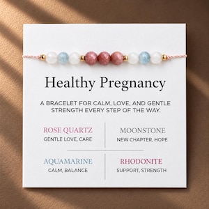 Pode incluir: Uma pulseira de contas num cartão branco com o texto Healthy Pregnancy, A BRACELET FOR CALM, LOVE, AND GENTLE STRENGTH EVERY STEP OF THE WAY. A pulseira tem contas facetadas em rosa, azul claro e branco com espaçadores dourados.