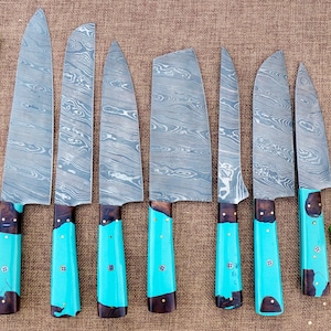 May include: A collection of seven Damascus steel kitchen knives with turquoise handles. The blades feature a distinctive water-like pattern. The handles are a bright turquoise with dark brown details. The knives are displayed on a brown surface.