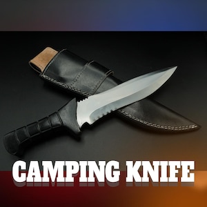 May include: A camping knife with a black handle and a silver blade, in a black leather sheath. The text "CAMPING KNIFE" is displayed in white letters at the bottom of the image.