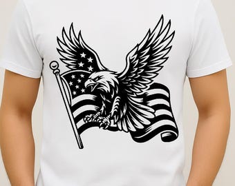 May include: White t-shirt featuring a black graphic of an eagle with outstretched wings, clutching an American flag. The flag has stars and stripes. The design is centered on the shirt.