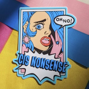 May include: A sticker featuring a distressed cartoon woman with blue hair, large eyes, and a speech bubble that says "OH NO!". The sticker also has the words "CIS NONSENSE" in a blue font.