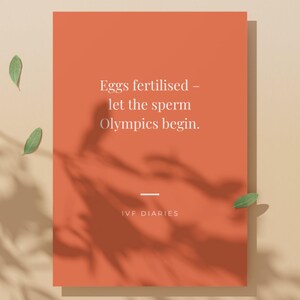 Op de afbeelding: Oranje kaart met de tekst "Eggs fertilised - let the sperm Olympics begin." en de woorden "IVF DIARIES" onderaan. De kaart heeft een schaduw en is versierd met groene bladeren.