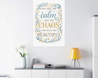 Może przedstawiać: Biały, prostokątny nadruk ścienny z napisem "You are the calm and the chaos and both are beautiful" w ozdobnej czcionce. Tekst jest w kolorze niebieskim i złotym, z kwiatowymi i gwiazdkowymi akcentami.
